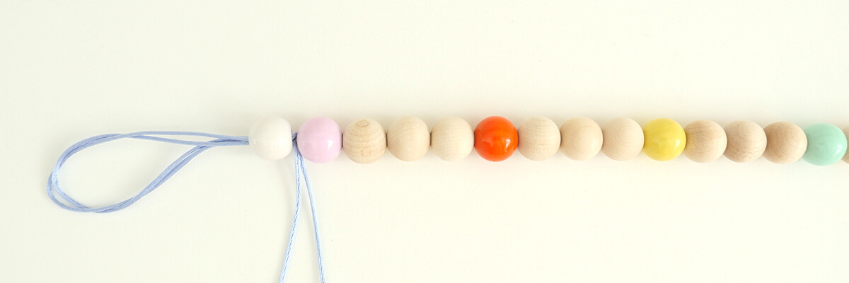 step-by-step instructions wooden bead rainbow garland: strung safety beads