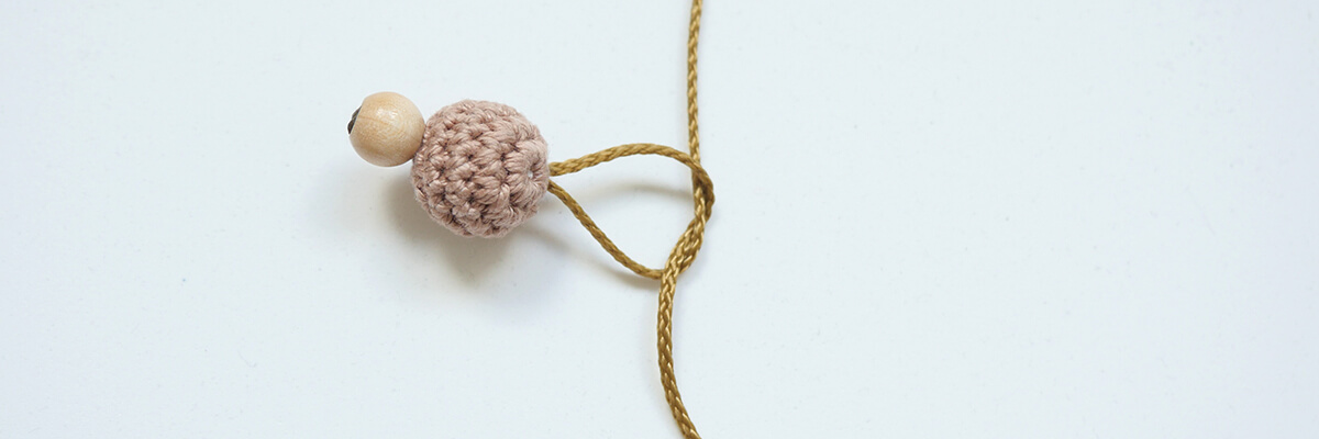 Instructions de fabrication d'une breloque en perles : un nœud simple pour une perle de sécurité